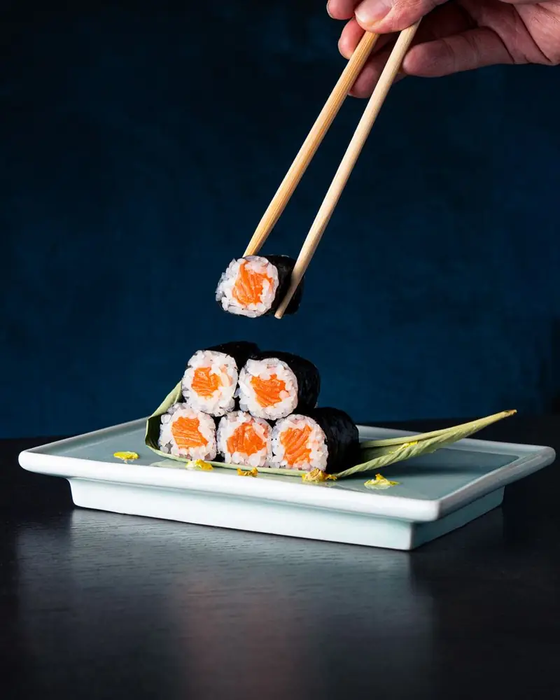 Hosomaki al salmone impilati su un piatto celadon